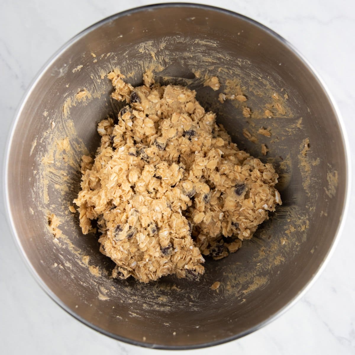 Rolled oats and dark chocolate chips are stirred into cookie dough.
