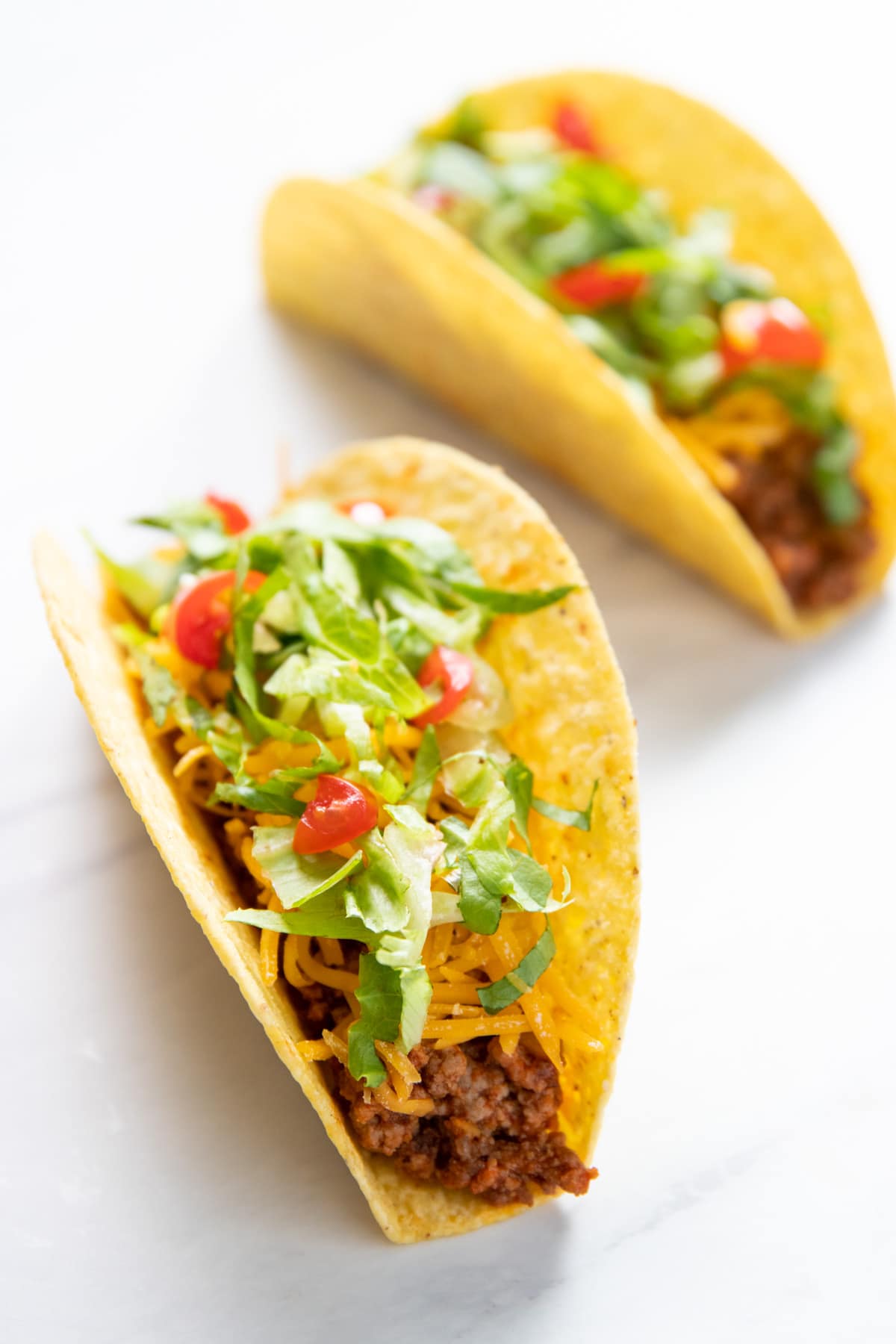 Two ground beef tacos in hard shells. 