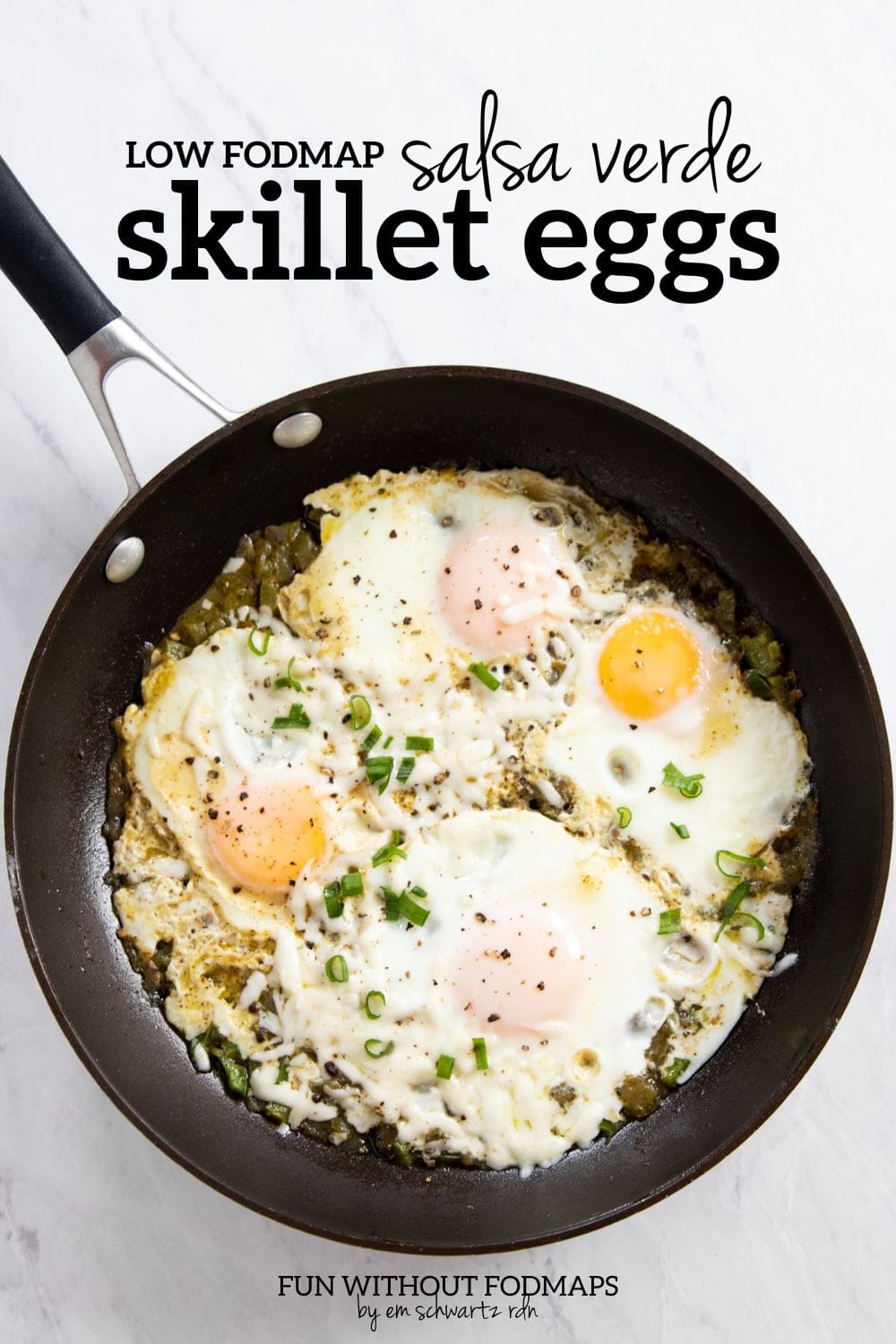 A skillet filled with cooked eggs and green salsa. In the white space above, black text reads "Low FODMAP Salsa Verde Skillet Eggs."
