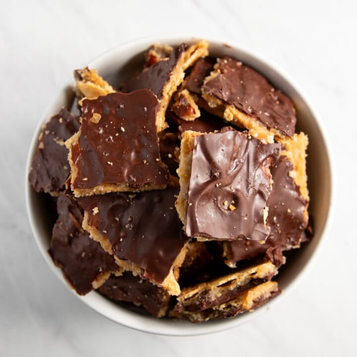 White bowl filled with pieces of low FODMAP cracker toffee.