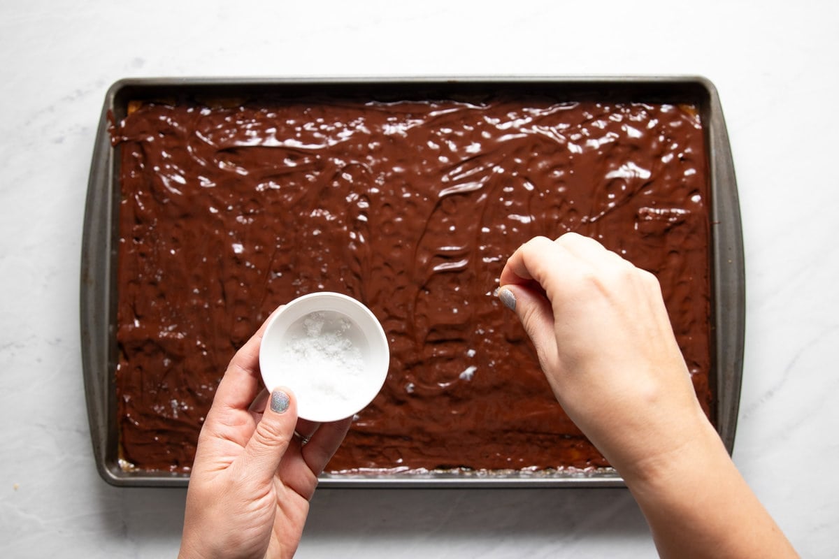 Sprinkling Maldon sea salt flakes on to the top of the melted chocolate of still-hot toffee bark.