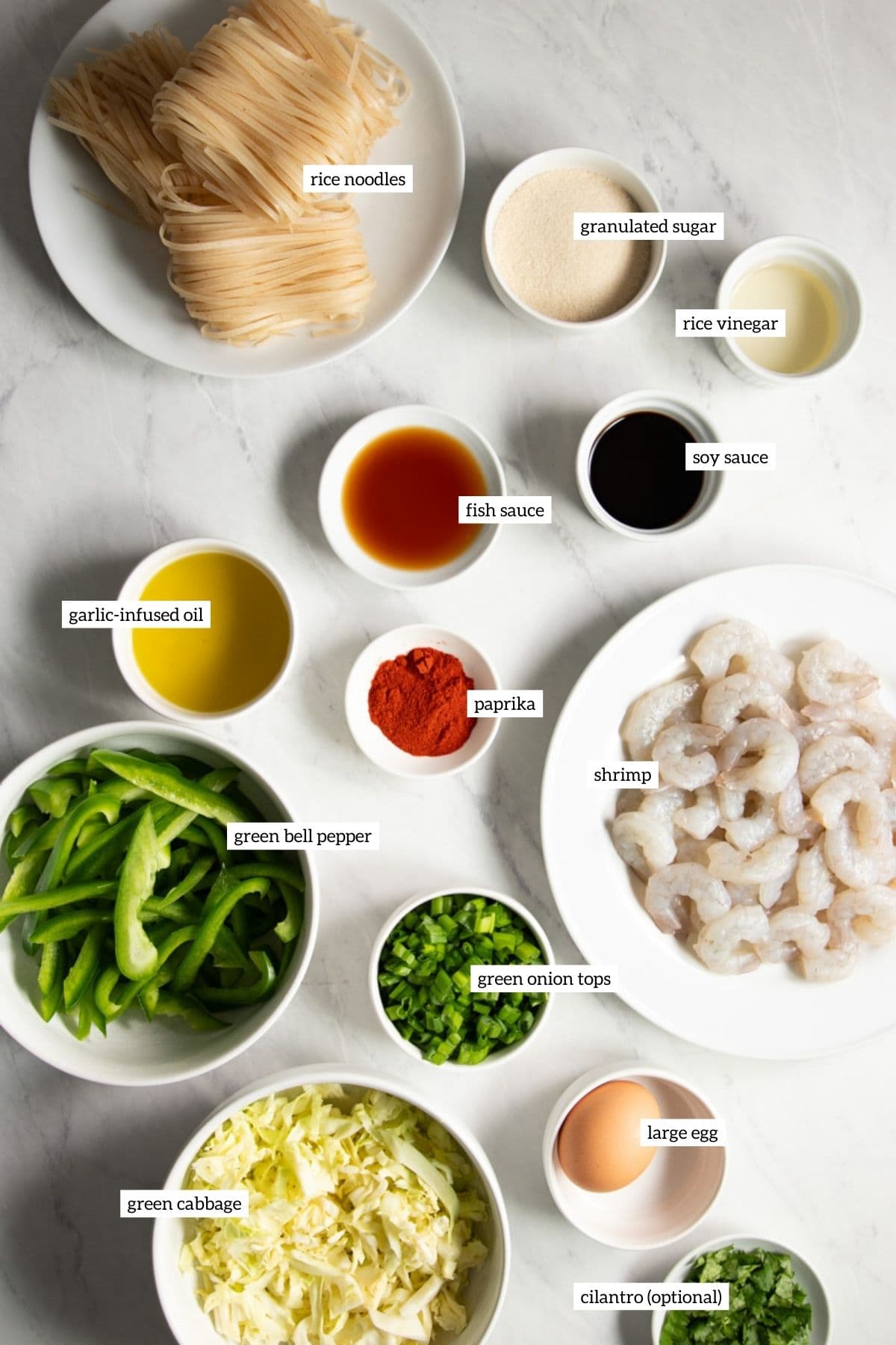 Ingredients needed for low FODMAP shrimp pad Thai prepared and measured out into individual white dishes.