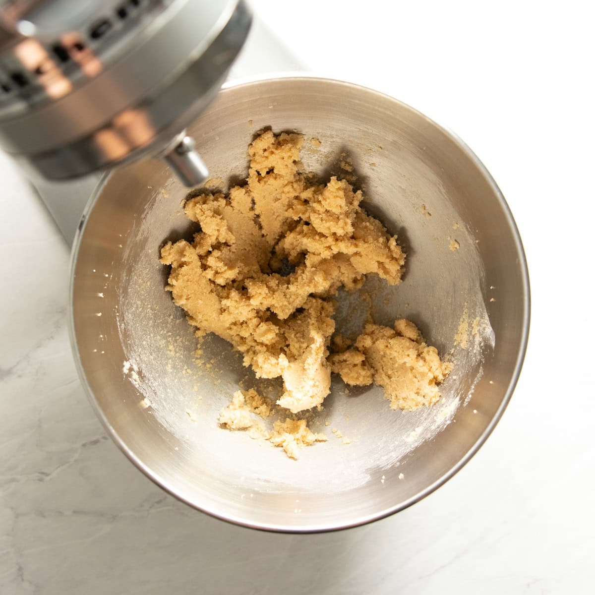 Stand mixer filled with a smooth mixture of softened butter, brown sugar, and granulated sugar.