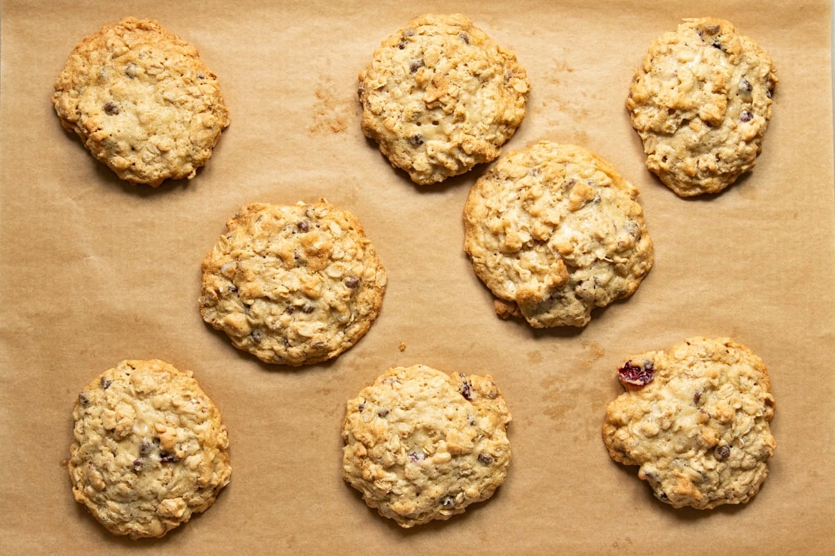 Baked low FODMAP trail cookies on a baking sheet lined with brown parchment paper.