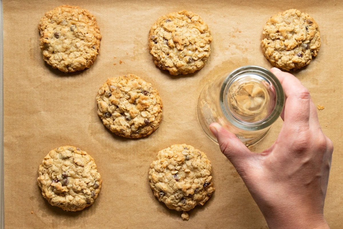 Swirling the open side of a glass around a still warm cookie to make the cookie more uniformly circular.