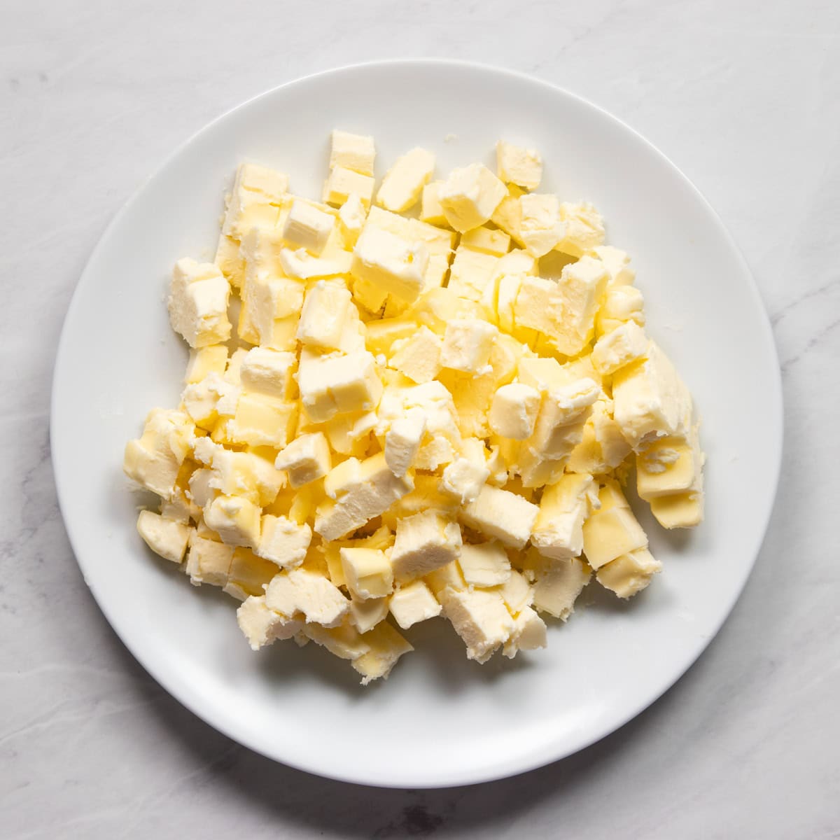 Small diced butter on a plate ready for the freezer.