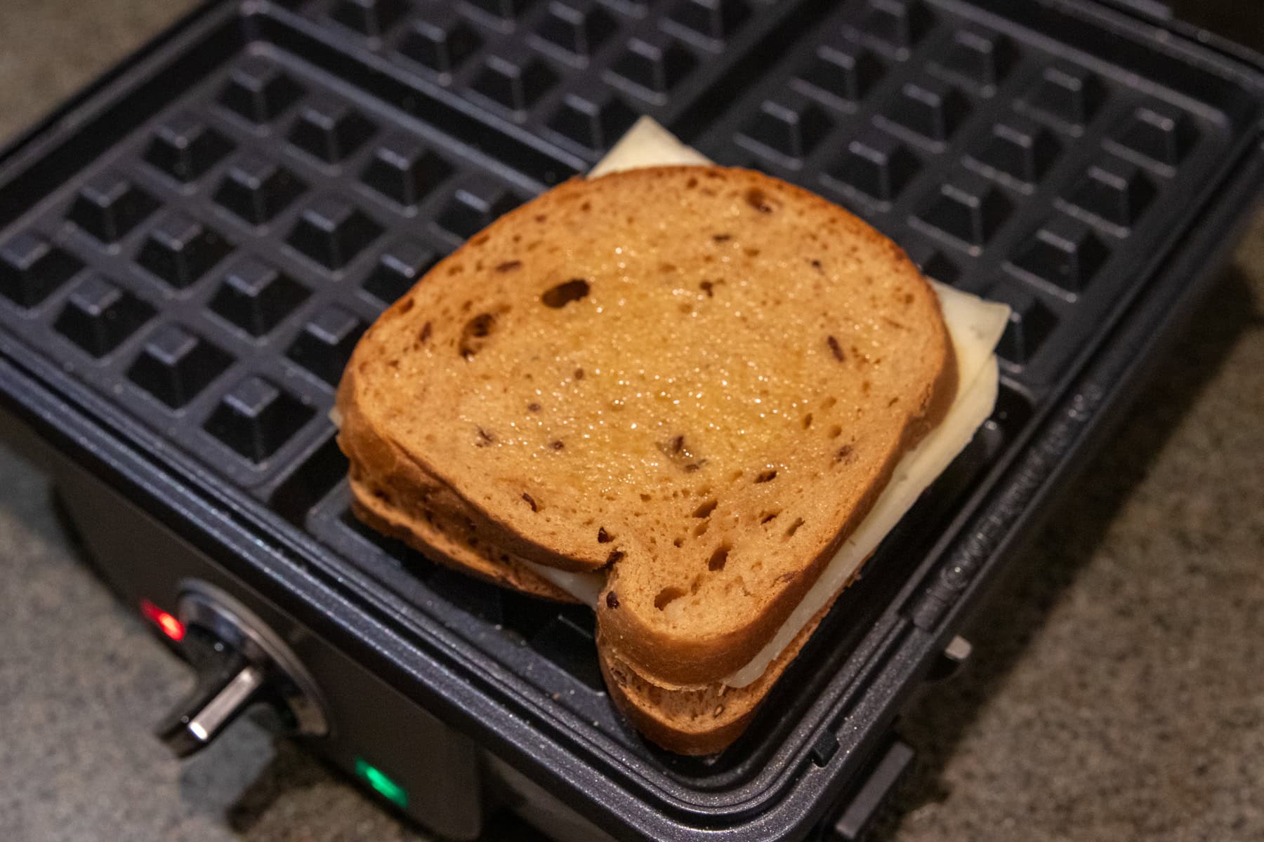 Cheese sandwich ready to get "grilled" on a preheated waffle maker.