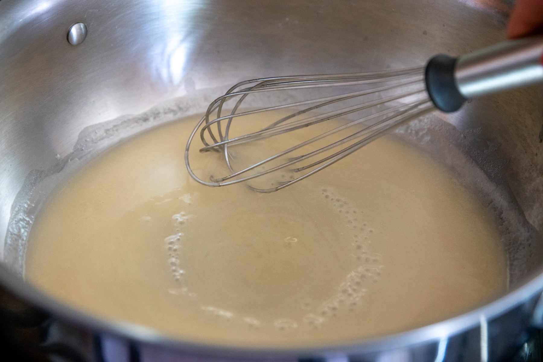 Lemon juice, white wine, and a cornstarch slurry are whisked into the melted butter and oil.