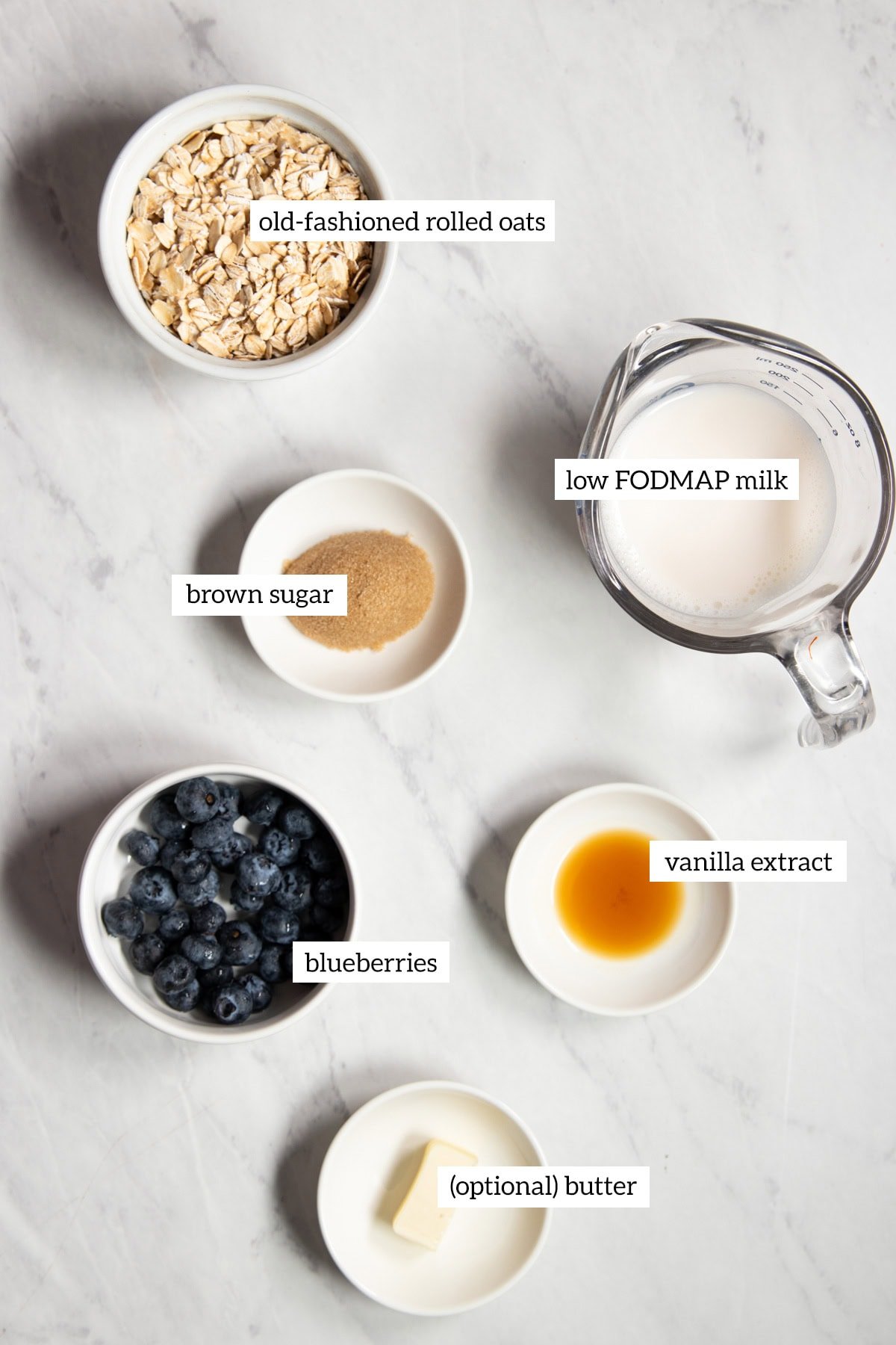 Ingredients needed for low FODMAP blueberry-vanilla oatmeal are prepared and measured out into individual dishes ready to cook.
