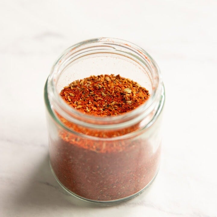 A small glass jar mostly filled with Low FODMAP Cajun Seasoning