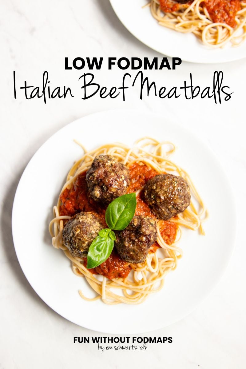 Looking down at two plates of spaghetti and meatballs. In the white space in between, black text reads "Low FODMAP Italian Beef Meatballs."