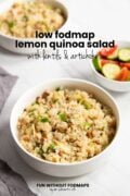Three bowls are on a counter. The focus is on one bowl filled with quinoa salad. In the background there are two more bowls - one contains quinoa salad and the other contains tomatoes and cucumbers. In the white space, a black text overlay reads "Low FODMAP Lemon Quinoa Salad with Lentils and Artichokes.