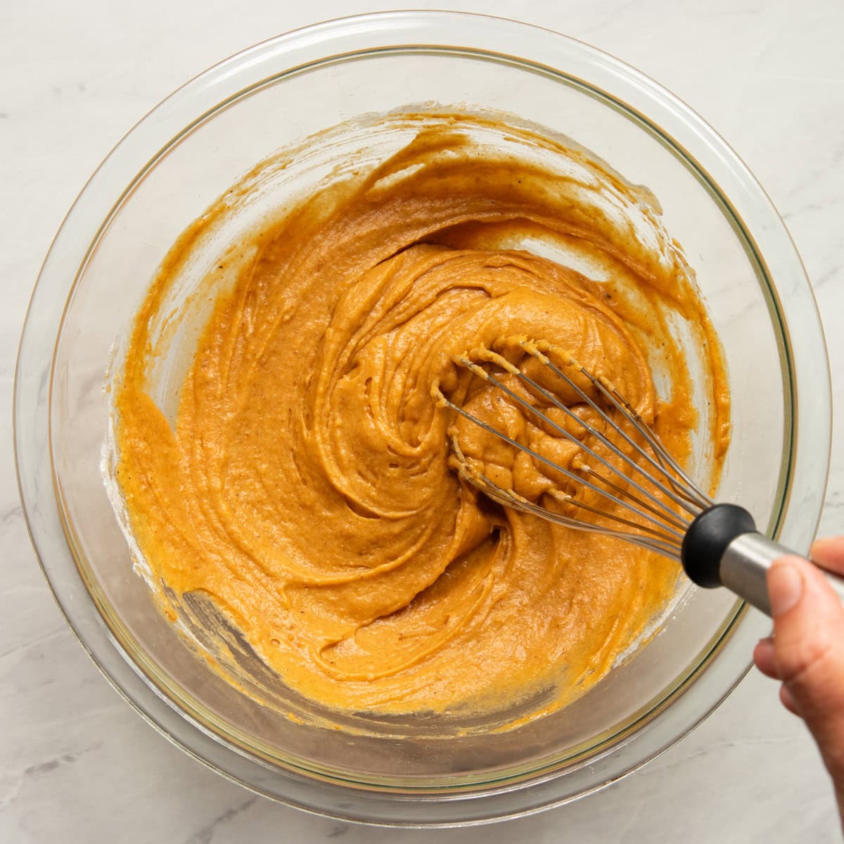 Dry ingredients are added to the wet ingredients for pumpkin waffles and whisked together until smooth.