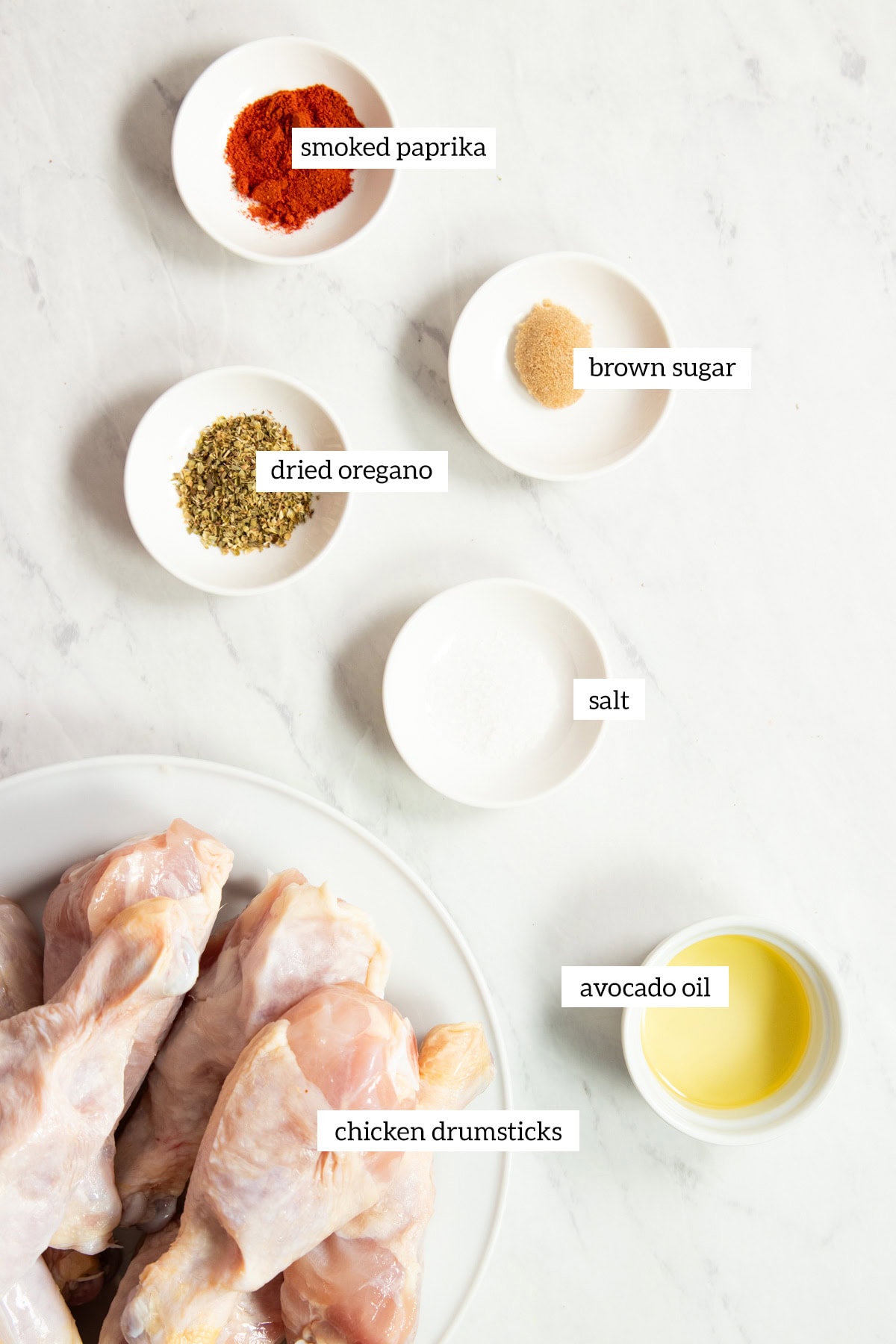 Ingredients needed for Low FODMAP Baked Chicken Drumsticks are measured out in to individual dishes ready for cooking.