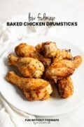 A pile of roasted chicken legs sits on a white plate surrounded by a white napkin. In the white space above, black text reads "Low FODMAP Baked Chicken Drumsticks."