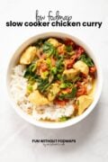 Looking into a bowl containing curry over rice. In the white space above, black text reads "Low FODMAP Slow Cooker Chicken Curry."