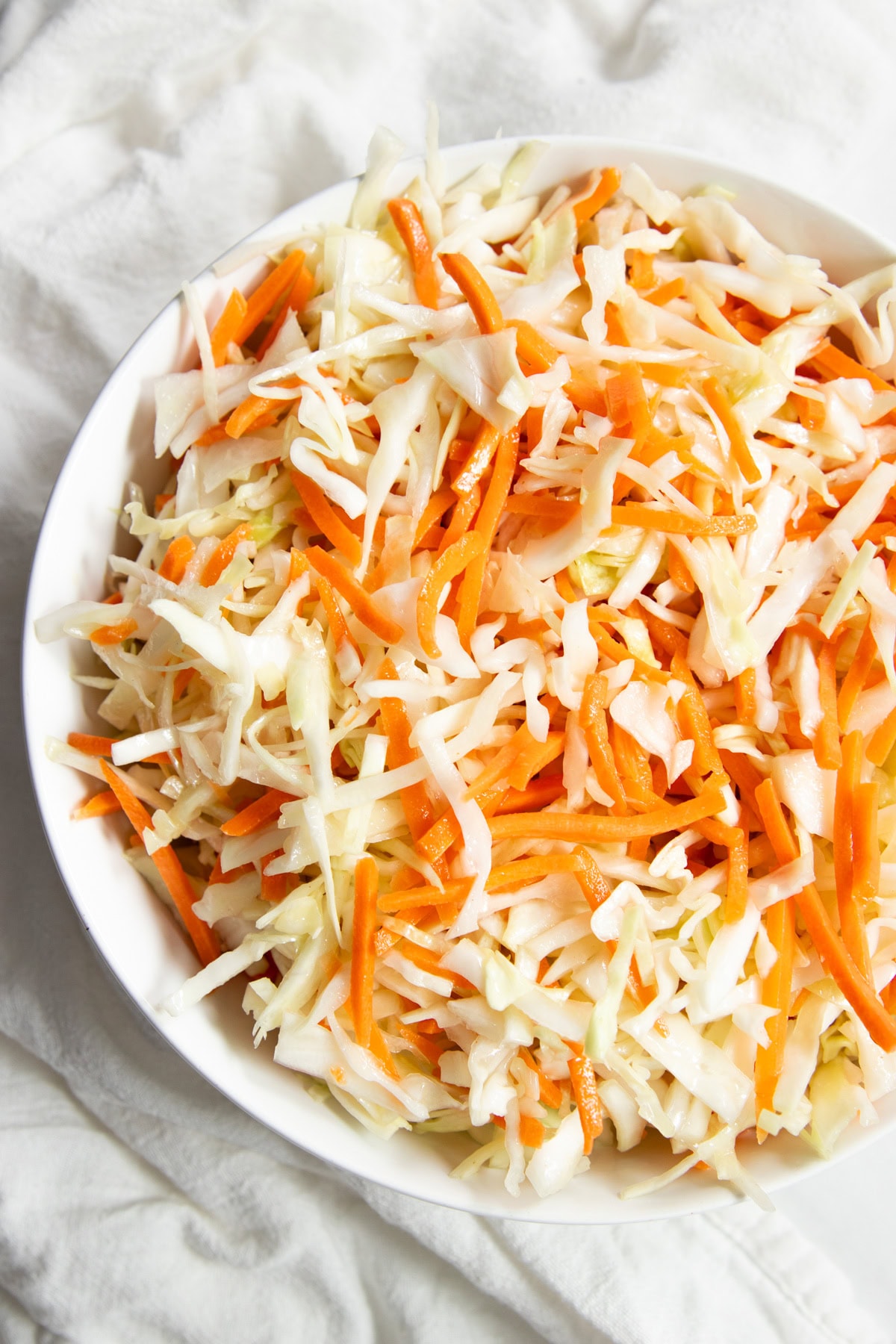 A close up of low FODMAP mayo-free coleslaw. You can really see the texture of the crunchy carrots and cabbage.