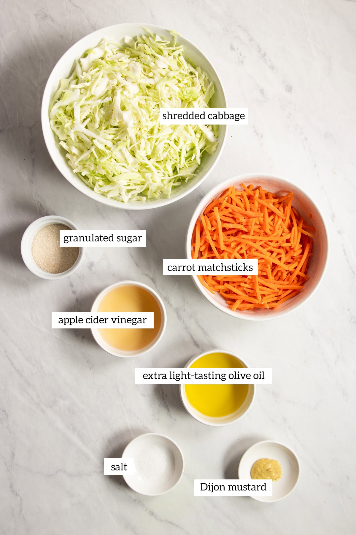 Ingredients needed for Low FODMAP Vinegar Coleslaw are prepared and measured out into individual dishes.