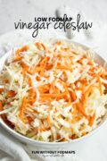 A bowl of coleslaw sits on a counter. In the white space above, black text reads "Low FODMAP Vinegar Coleslaw."