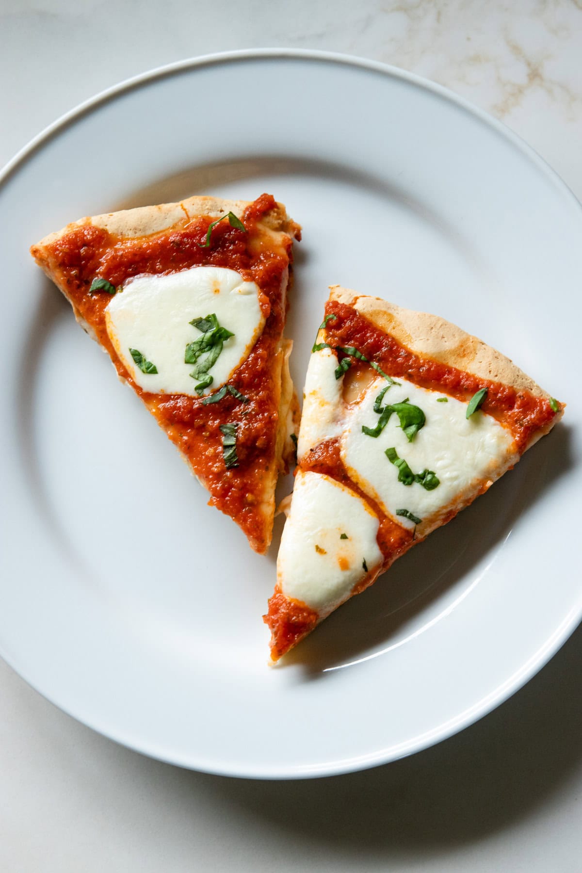 A low FODMAP serving of this cheese pizza consisting of two slices or a quarter of the whole recipe.