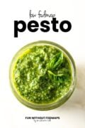 A close up of a small mason jar filled basil pesto. In the white space above, black text reads "Low FODMAP Pesto."