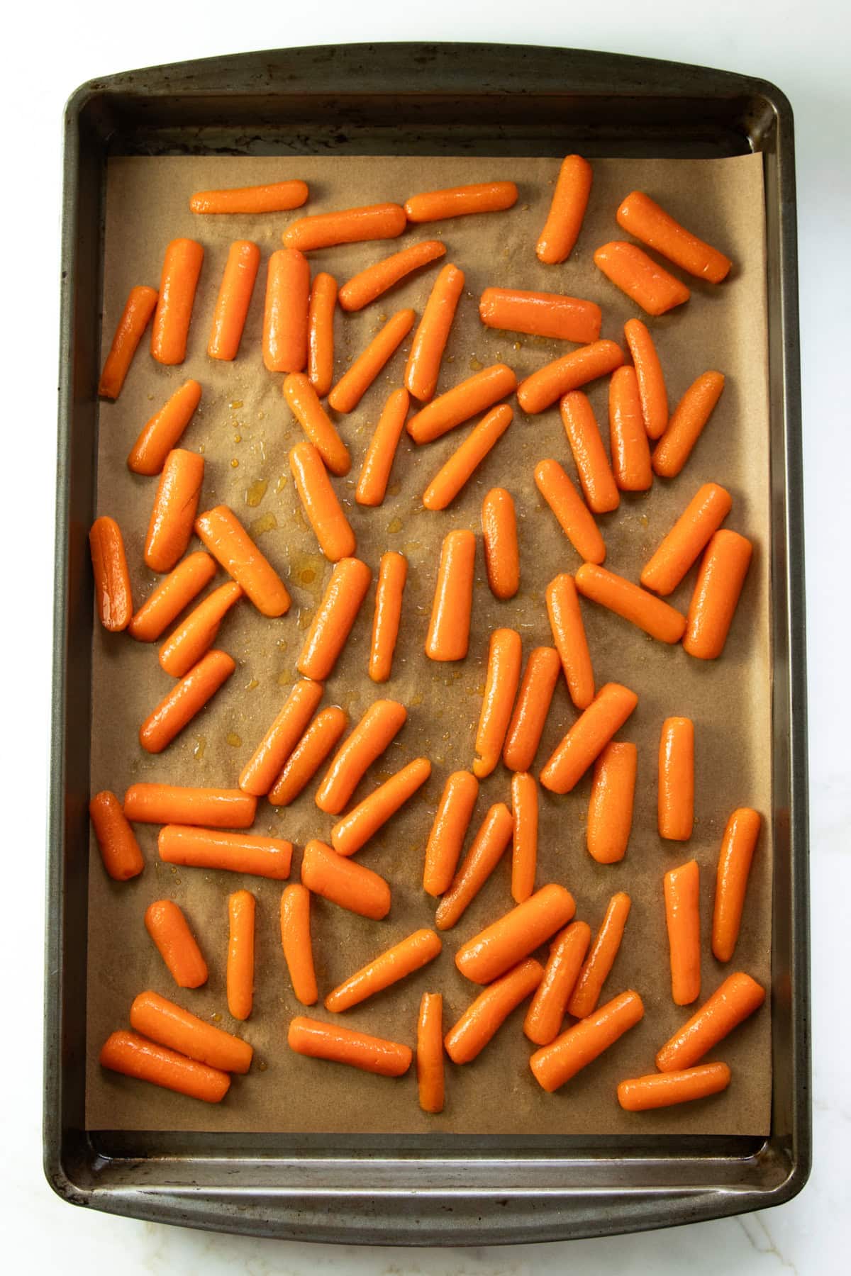 Baby carrots halved lengthwise, tossed with oil and soy sauce, and arranged cut side down on a parchment-lined sheet pan