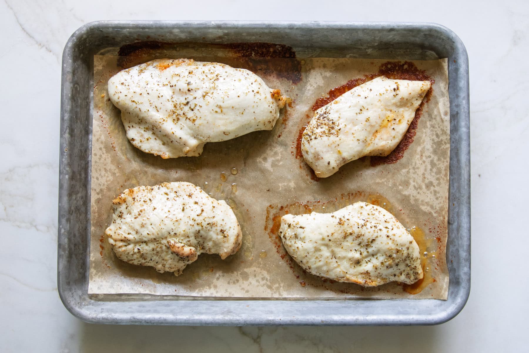 Roasted chicken breasts on a sheet pan.