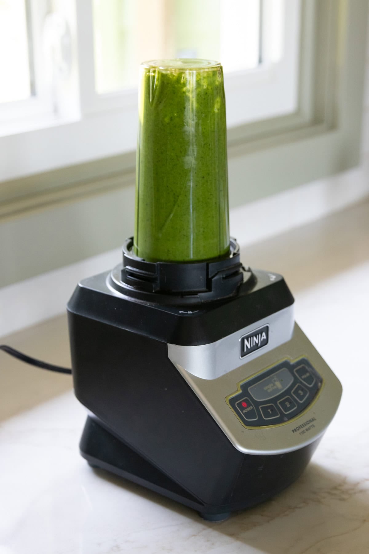 Blending low FODMAP pesto in a small blender.