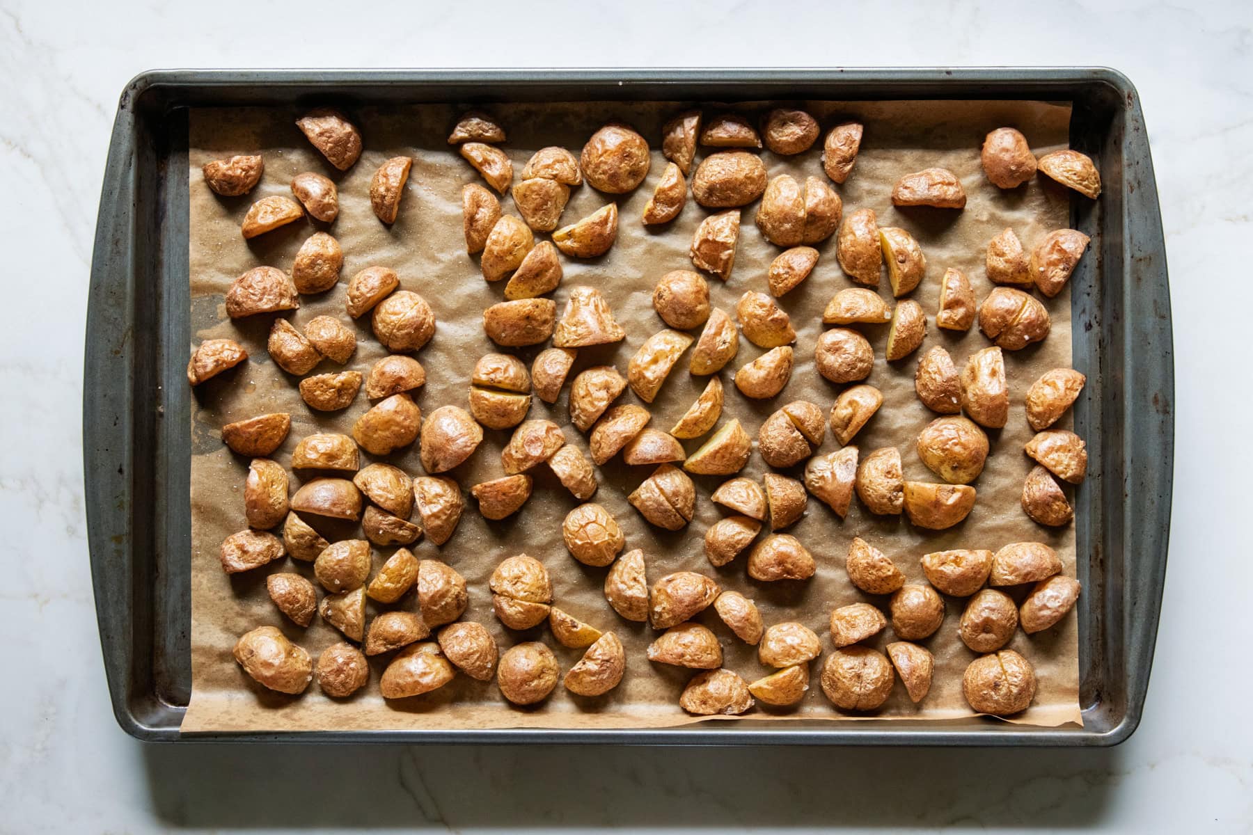 Roasted baby potatoes on a sheet pan.