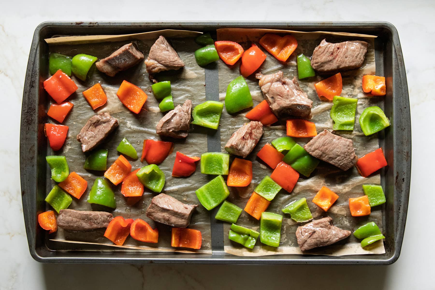 Roasted peppers and steak on a sheet pan.